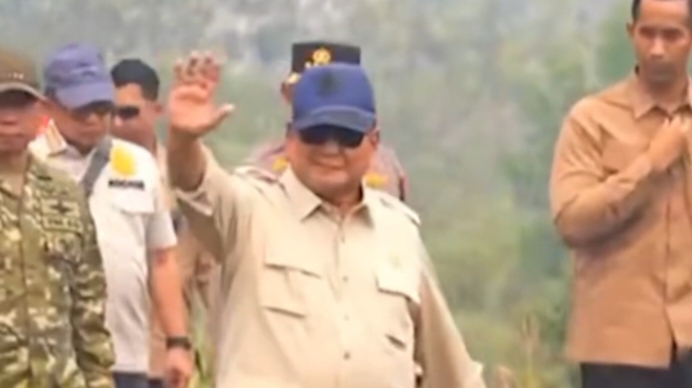 Presiden Prabowo Subianto berjalan kaki menyusuri lahan terbakar penuh asap.